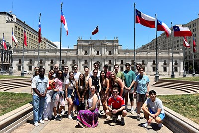 A group of two dozen students pose for a photo in front of the presidential palace in Santiago, Chile