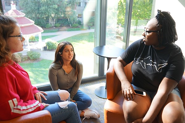 First-year Honors College students at UMass Lowell discuss a group project. From left to right, Kat Tripp, Alejandra De Angel and Mercy Olu.