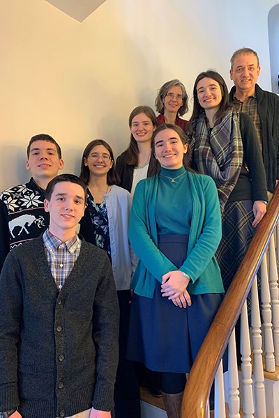 Eileen and Christopher Peters, top, with their six homeschooled children on a staircase at UMass Lowell's Allen House, home of the university's Honors College