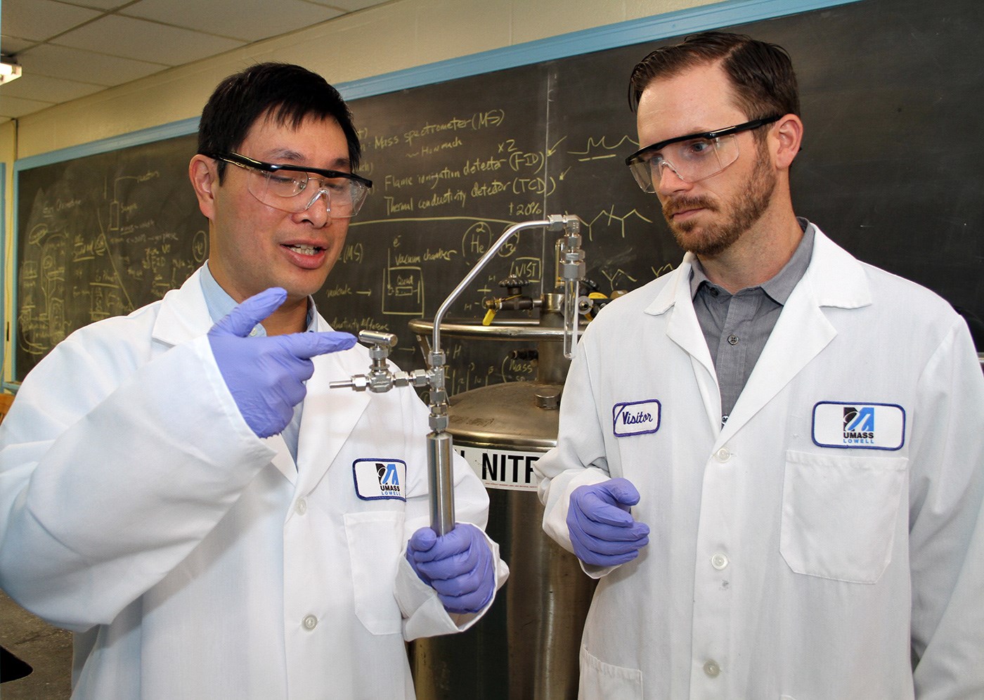 Asst. Profs. Hsi-Wu Wong and Hunter Mack examine the reactor used in creating biofuels in the lab.