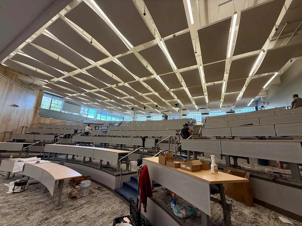 Construction workers work on a college lecture hall.