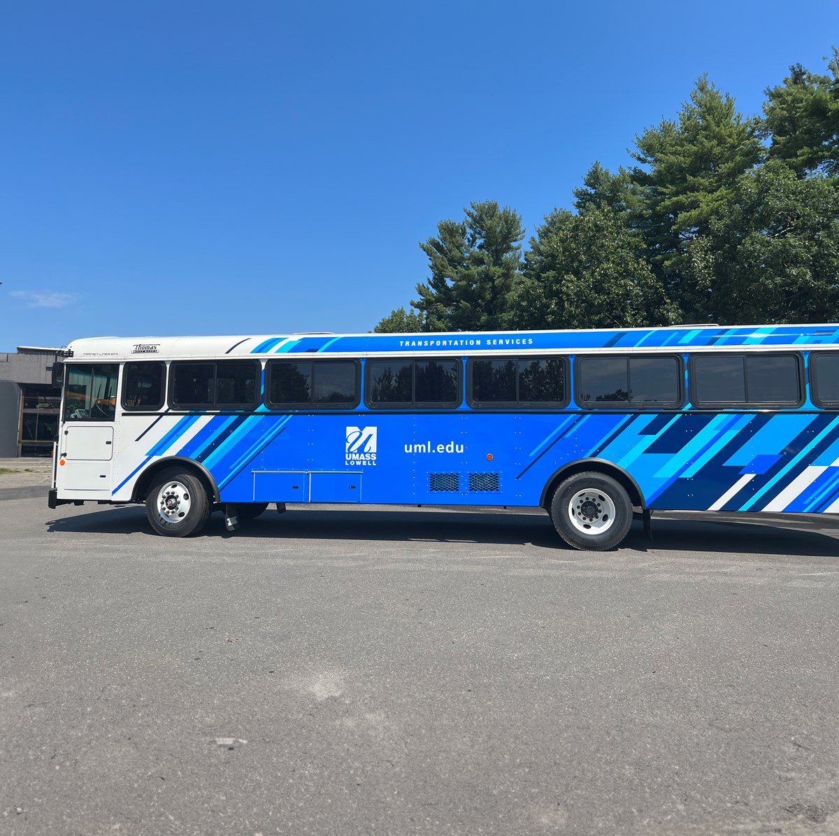 A big blue UMass Lowell branded bus