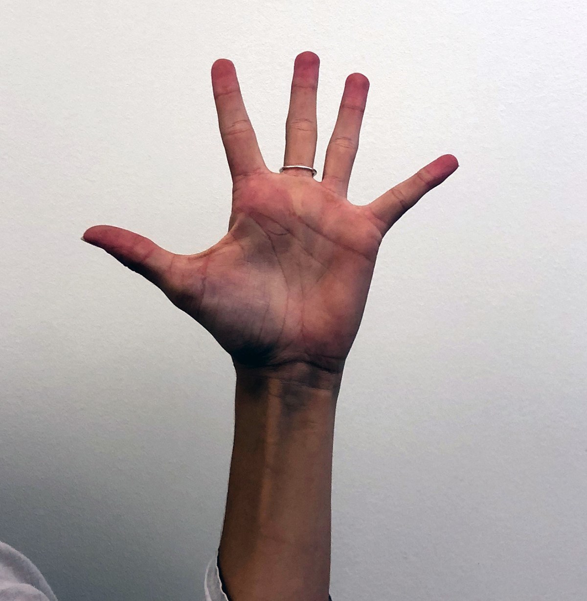 A hand is spread out so each finger is as far away as possible 