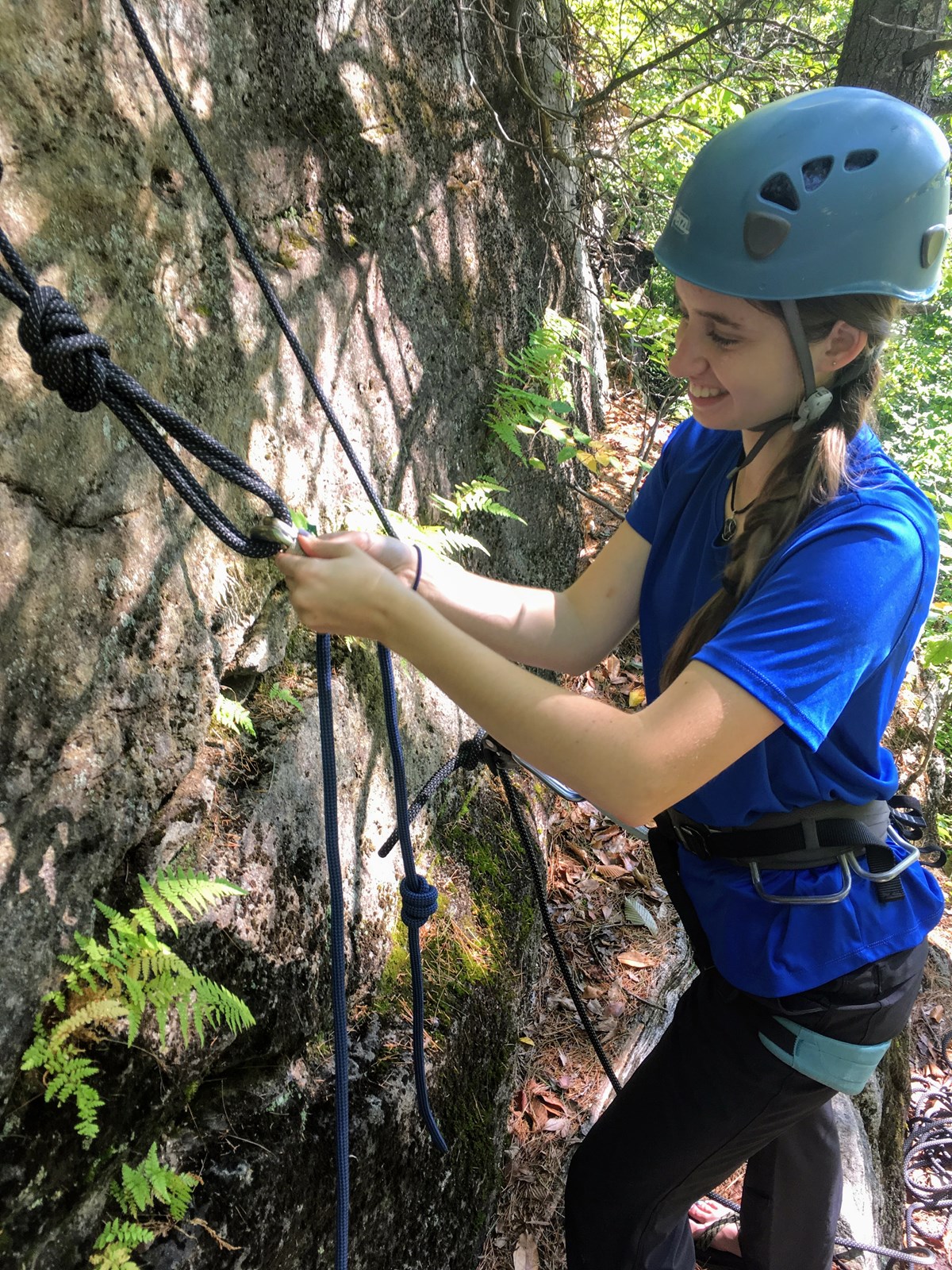 Young woman setting up a climbing anchor