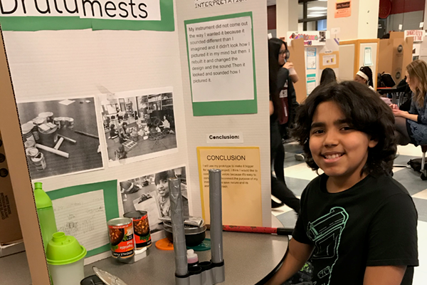Stoklosa Middle School fifth grader Kedwin Santiago Torres proudly shows off his part in the EcoSonic Project during the recent regional science fair in Lowell.