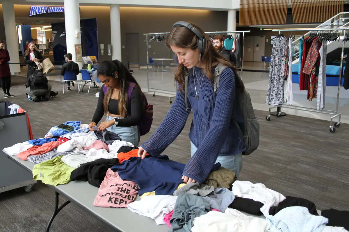 Two students sift through clothes.