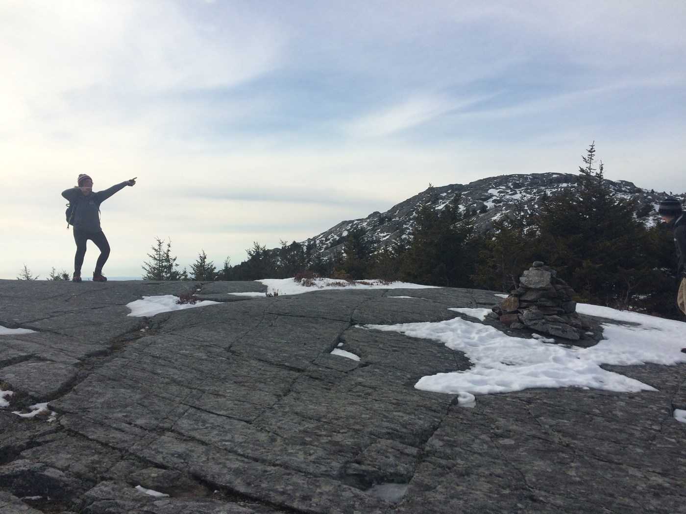 Hiker Pointing to Mountain Summit in Winter