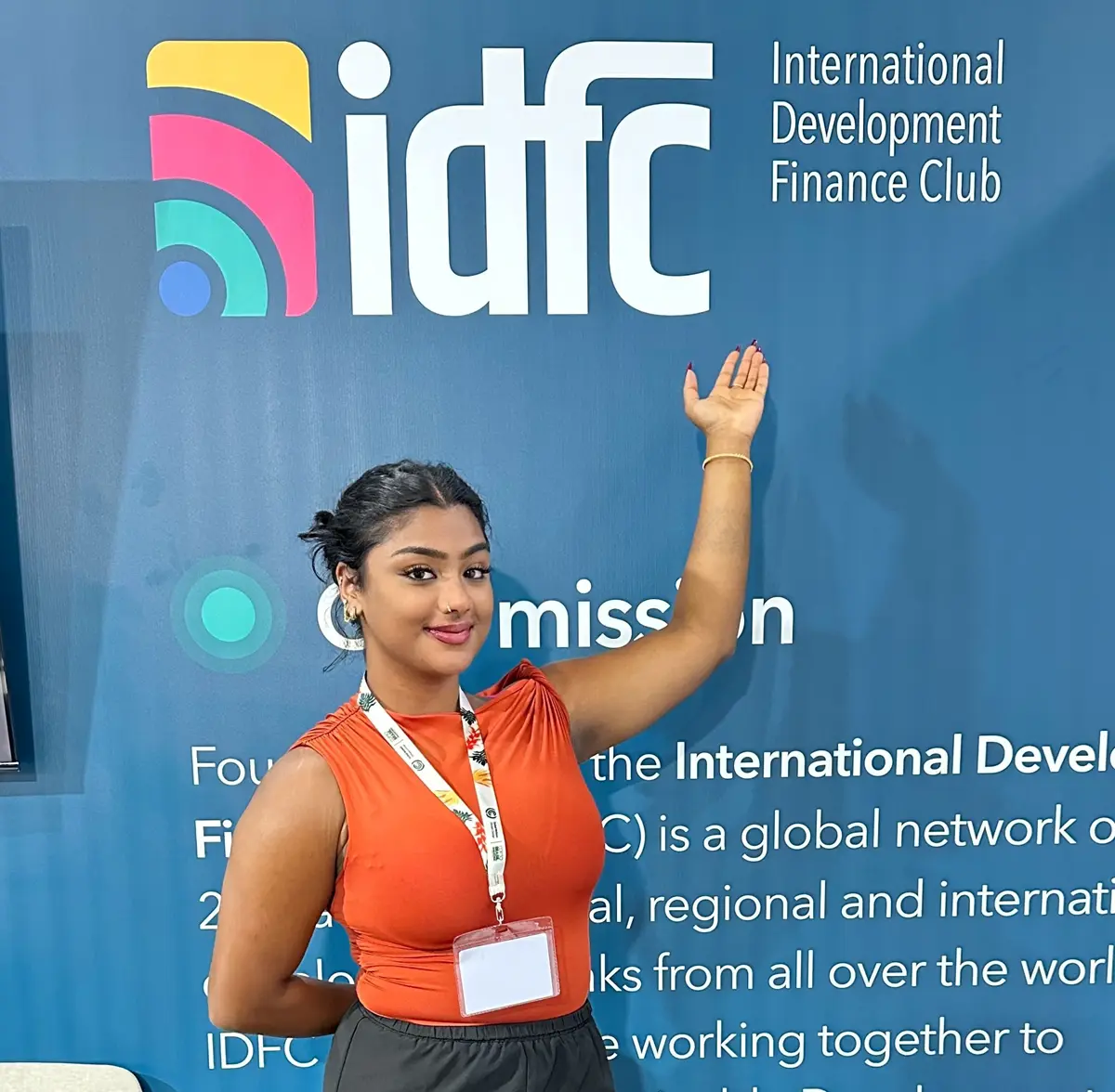 Angel Molekunnel stands under an International Development Finance Club sign.