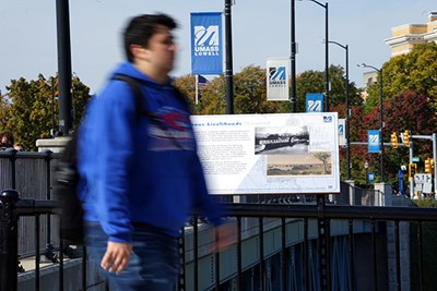 A student walks past an educational sign about Indigenous peoples