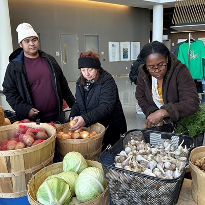 Shoppers choose vegetables at an indoor farmers market