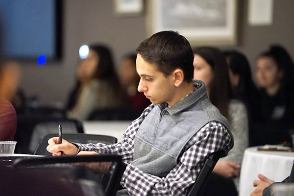 A student takes notes during the Internal Audit panel discussion