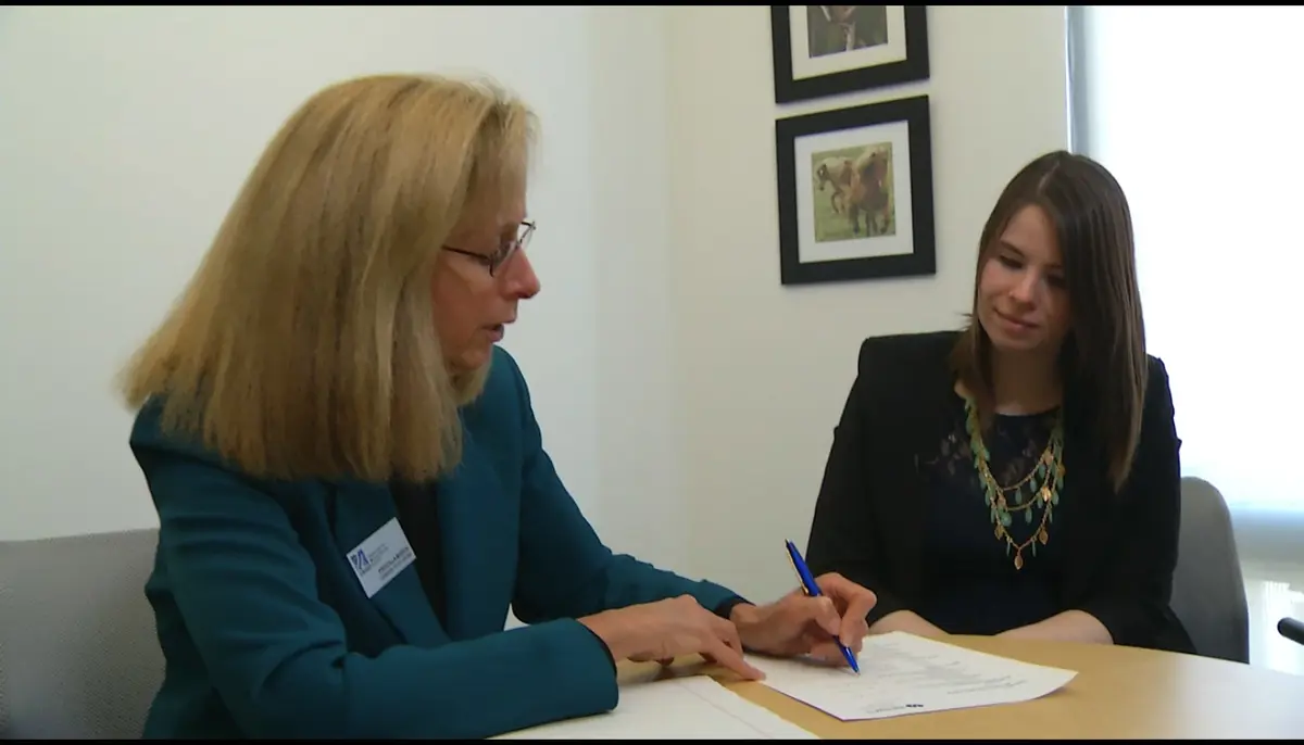 A UML faculty member assisting a student on filling out an internship form.