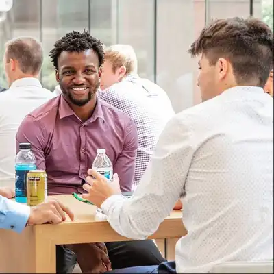Two people seated at a table in a crowded room.
