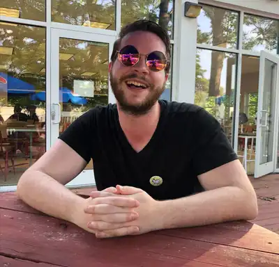 Jack Croughwell wearing sunglasses seated outside.
