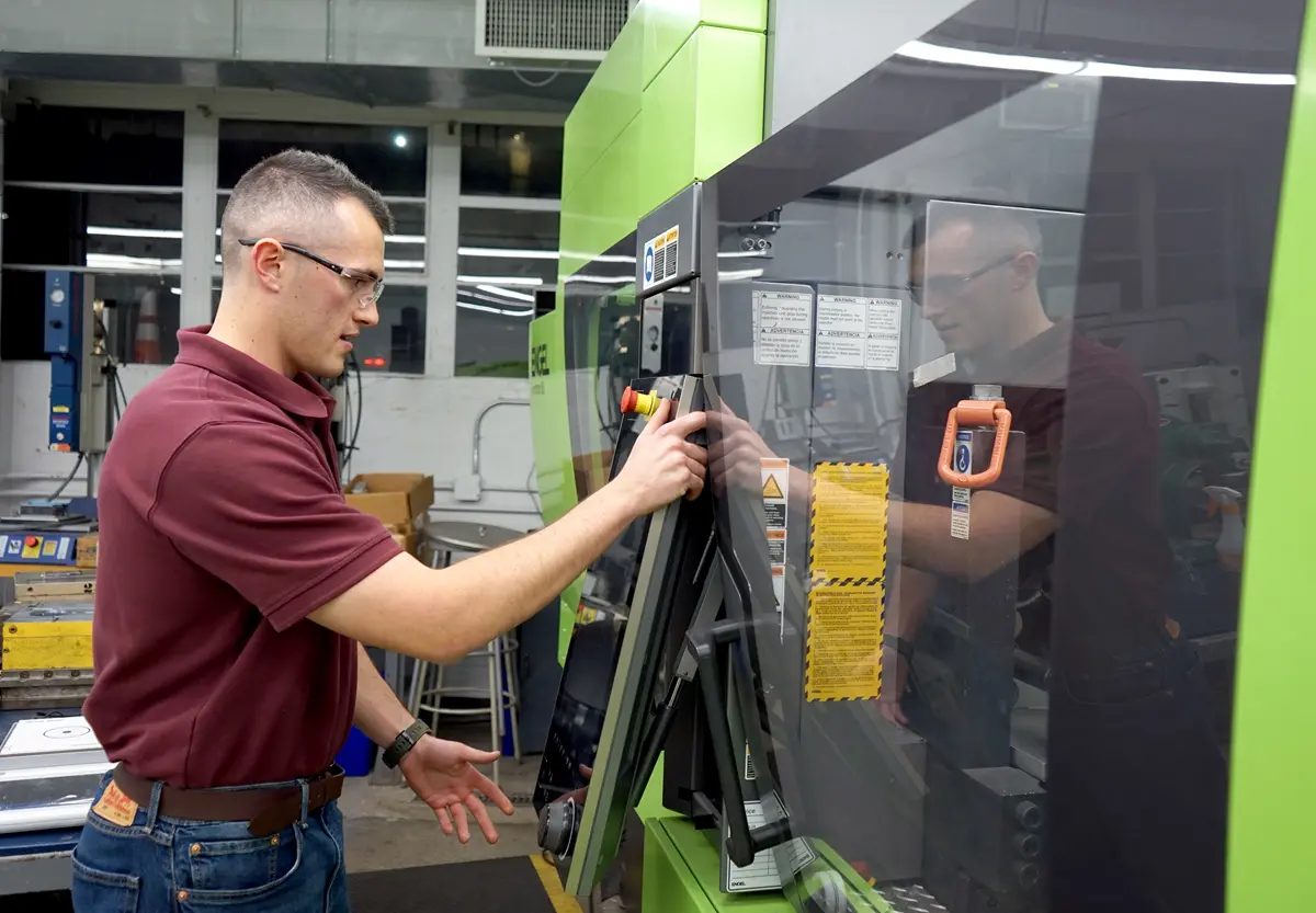 Jack Sullivan works with machinery in a UMass Lowell plastics engineering lab.
