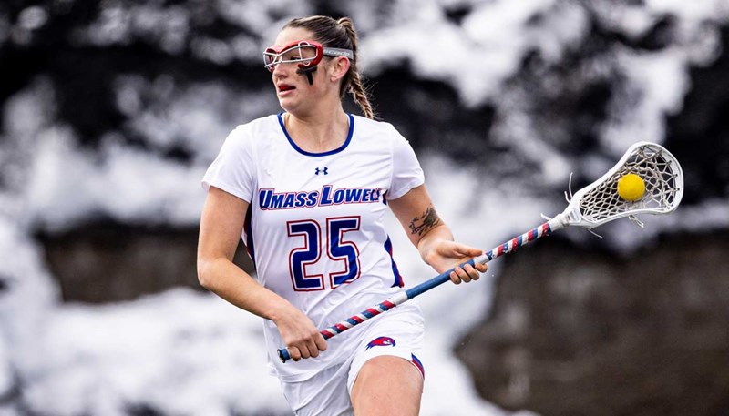 UMass Lowell student-athlete Jade Catlin runs while holding a lacrosse stick.