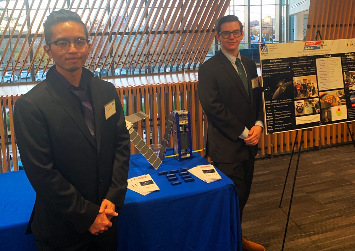 Janalvin Arbiol (left) and Alexander Barr (right) are standing in front of their table and poster. 