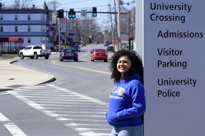 Jenna Howard leans against a UML sign on Pawtucket Street