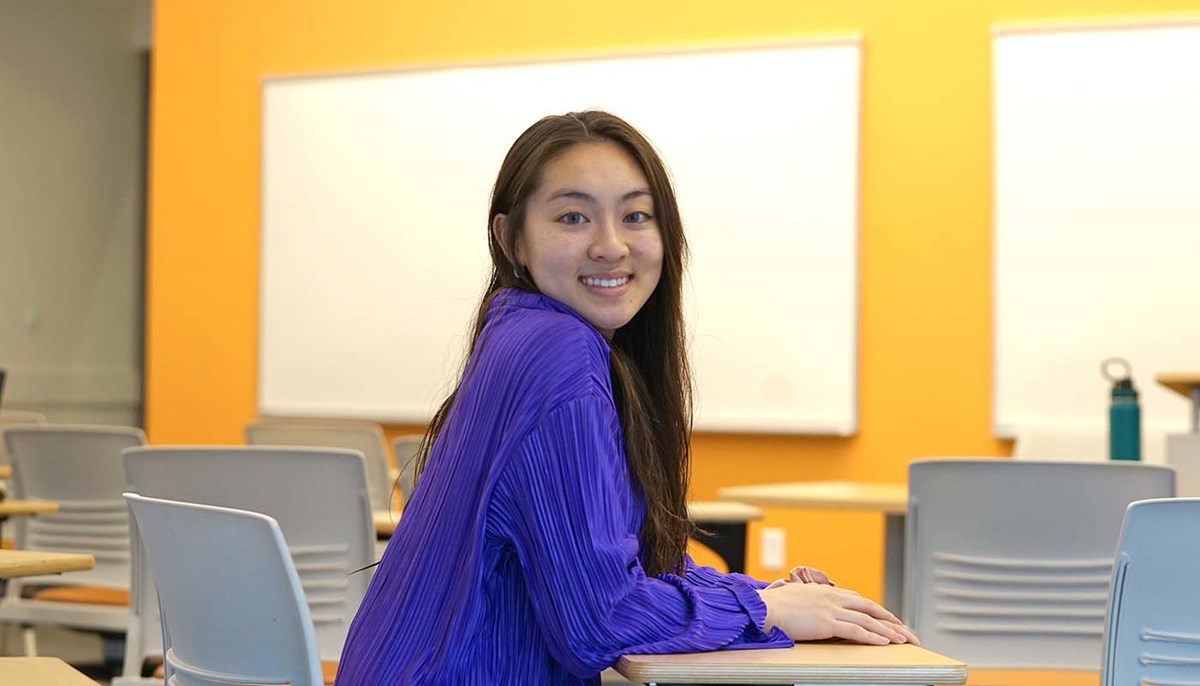 Jessica Tran is sitting in a classroom