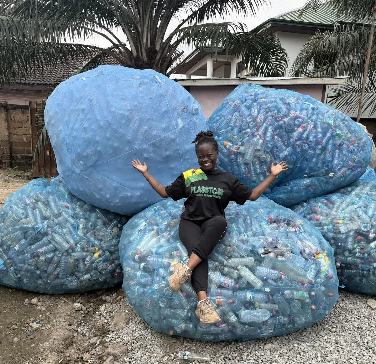 Plasatoss founder and UMass Lowell plastics engineering student Joanita Amoah is dwarfed by some of the material she's collected as part of a project to recover and convert plastic waste in Ghana into raw material for manufacturing.