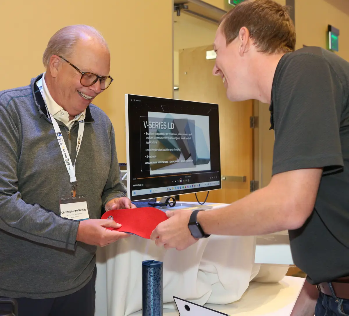 Christopher McNerney of Rubberlite Inc. hands a red item to a UMass Lowell student.