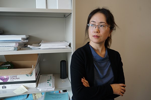 Business professor Julie Zhang looks out her office window