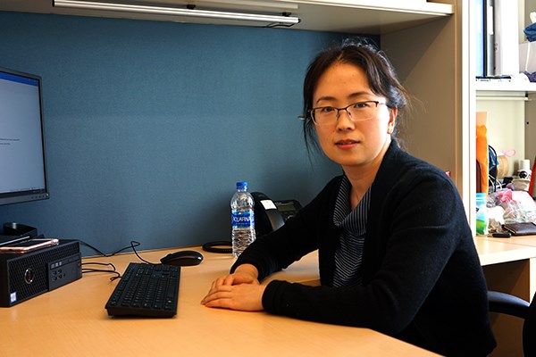 Julie Zhang sits at her office desk