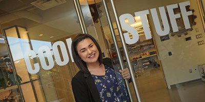 Co-op student opening glass doors with words cool stuff