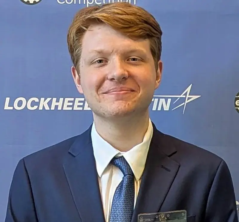 Kenneth Hawkey standing against a Lockheed Martin Ethics in Engineering Competition background.