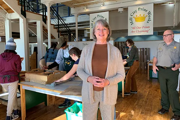 Sheila Kirschbaum stands in front of students on an assembly line at the Tsongas Industrial History Center.