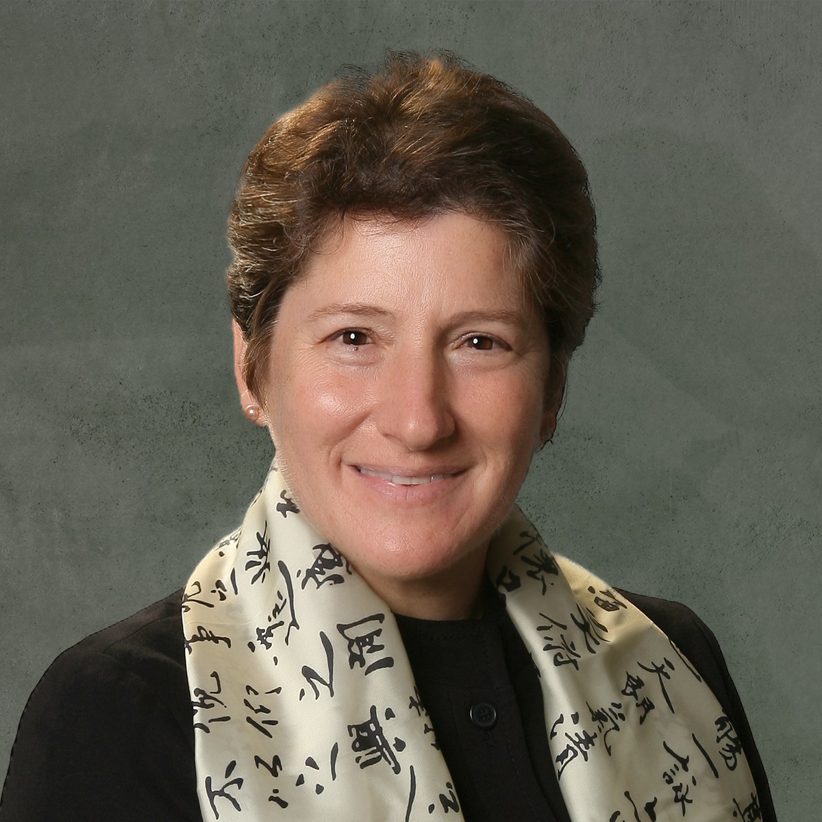 Julia A. Kornfield wearing a scarf and smiling at the camera.