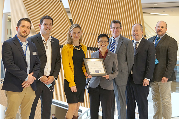 Secretary for Energy and Environmental Affairs Kathleen Theoharides, third from left, poses with UMass Lowell's, from left, Dan Abrahamson, Ruairi O'Mahony, Julie Chen, Steve O'Riordan, Thomas Miliano and T.J. McCarthy at the Leading by Example awards at University Crossing.