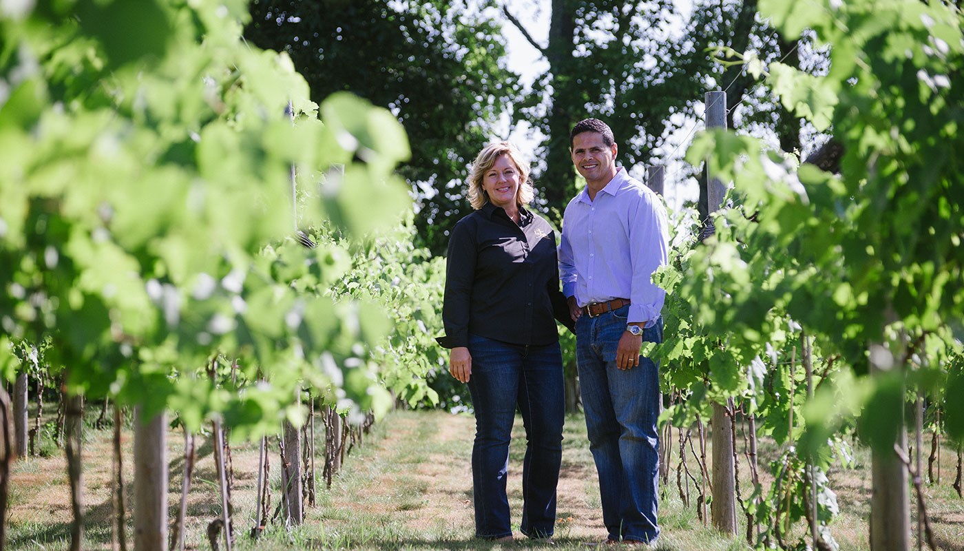 Owners of LaBelle Winery standing in the vineyard