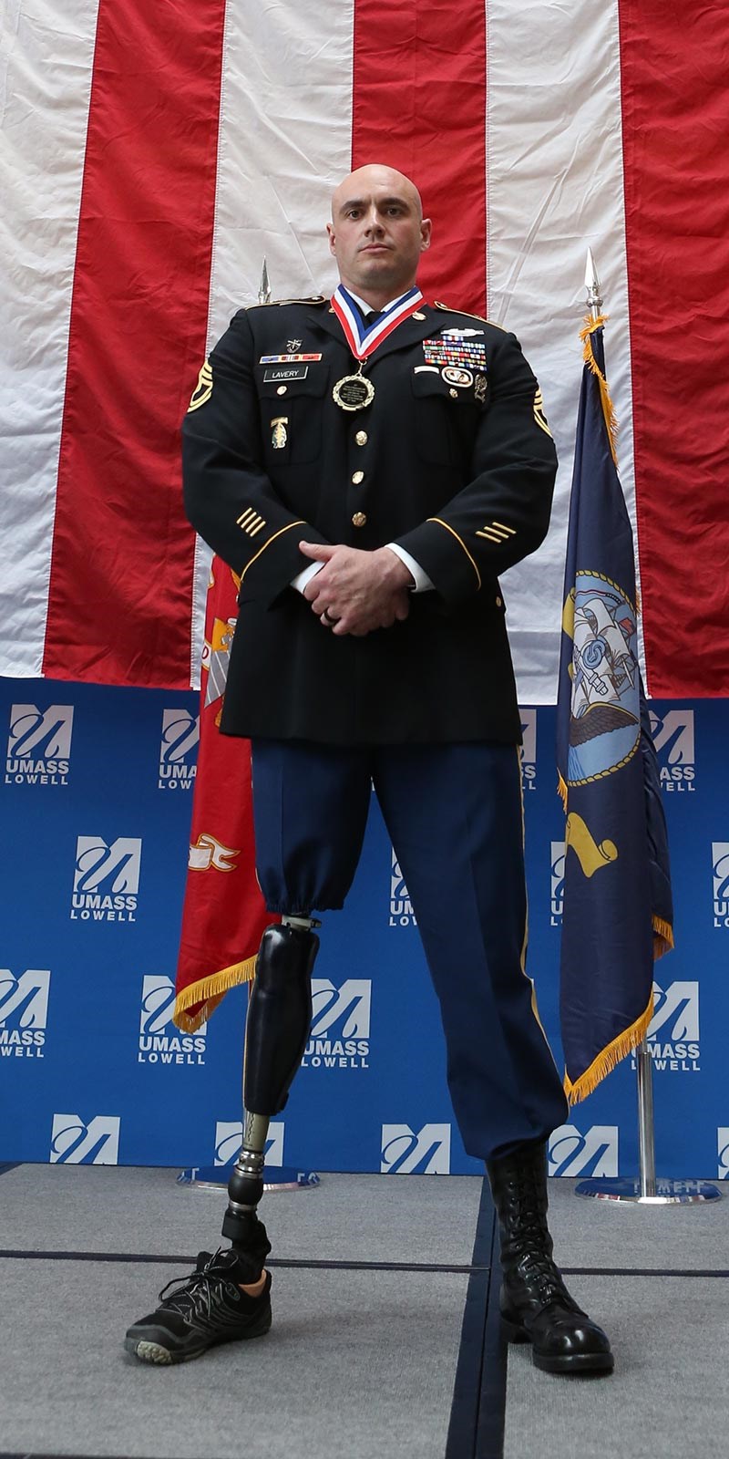 Alumnus, veteran and amputee Nick Lavery stands in front of American flag