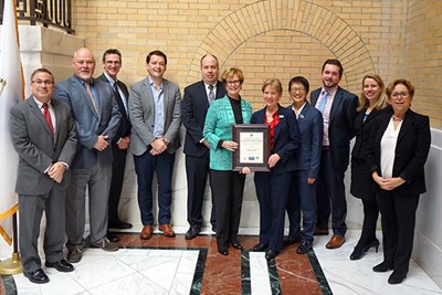 Chancellor Moloney and UML staff pose with DOER and DCAMM officials with the Leading by Example award