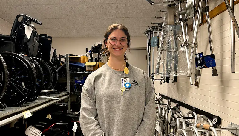 Leah Sacco with wheel chairs and other medical equipment in the background.
