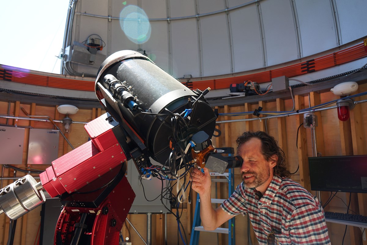 Physics Assoc. Prof. Silas Laycock looking into a telescope at the observatory.