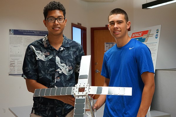 Liono and Matt, mechanical engineering students at the Lowell Center for Space Science and Technology with the CubeSat satellite