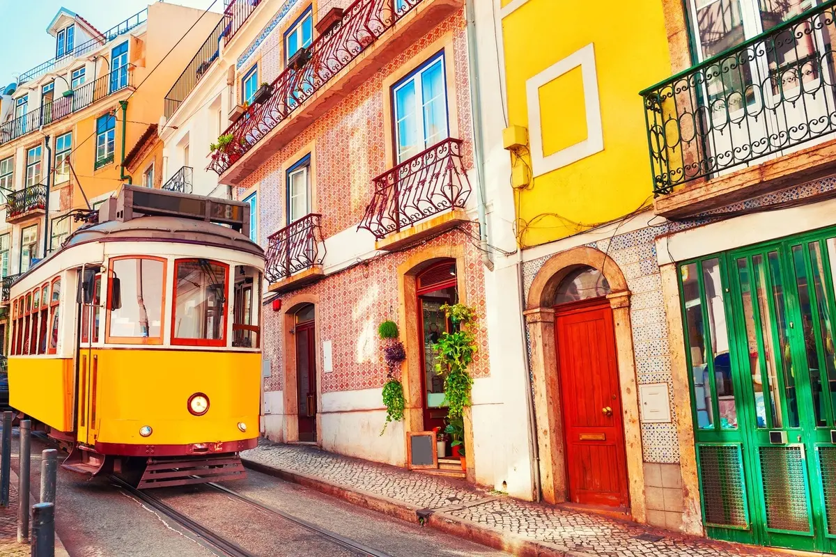 Cable car on narrow colorful residential street in Lisbon Portugal. 