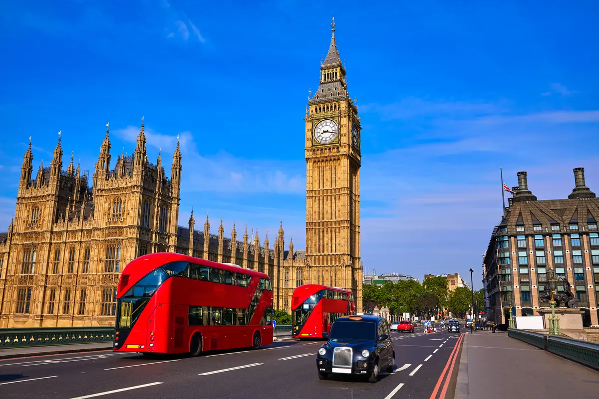 Street scene of Big Ben clock tower, London bus and London cab.
