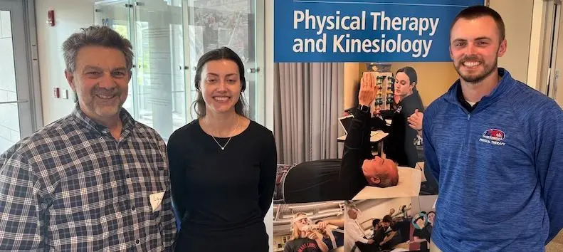 Lou Coiro with Macey Bussiere and Ian Ferris in front of a Physical Therapy and Kinesiology sign.
