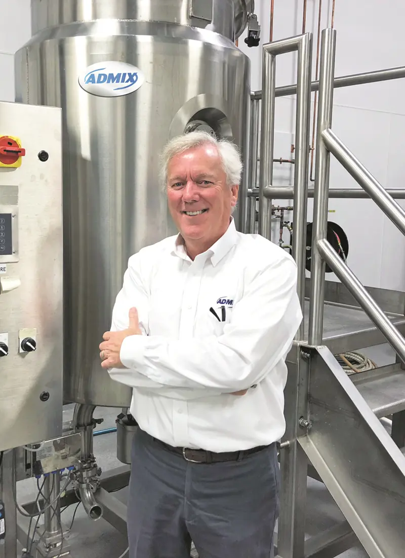 Louis Beaudette stands in front of a machine at Admix