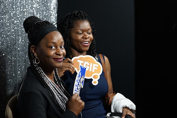 Two young women have their photo taken in the photo booth at the ceremony