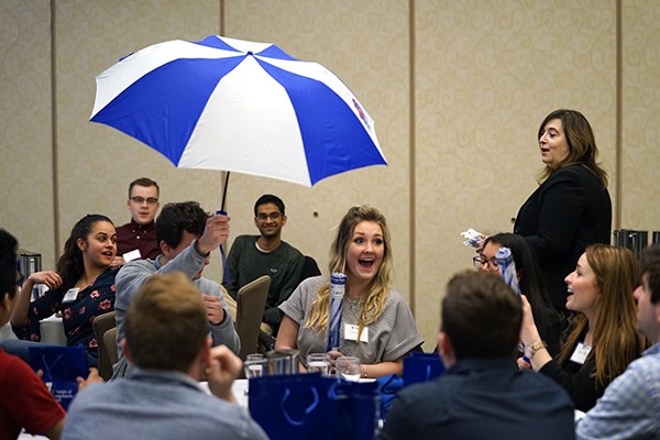 A student opens an umbrella during the Manning student leaders dinner
