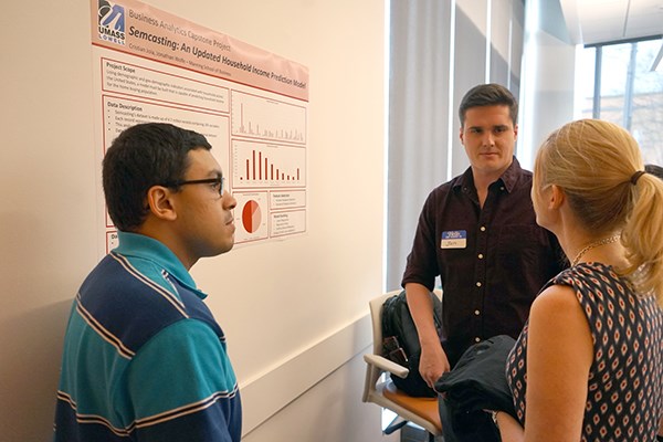 Students Jonathan Wolfe and Cristian Joia discuss their capstone project with a guest