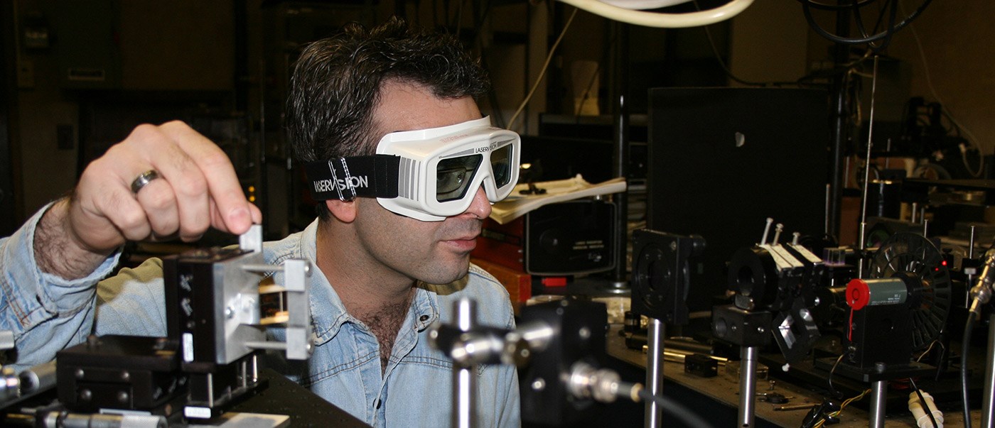 Electrical and Computer Engineering student wearing goggles and working with unknown equipment.