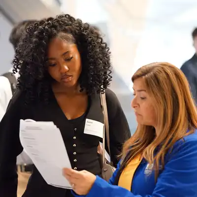 Student looks at a document with an advisor.