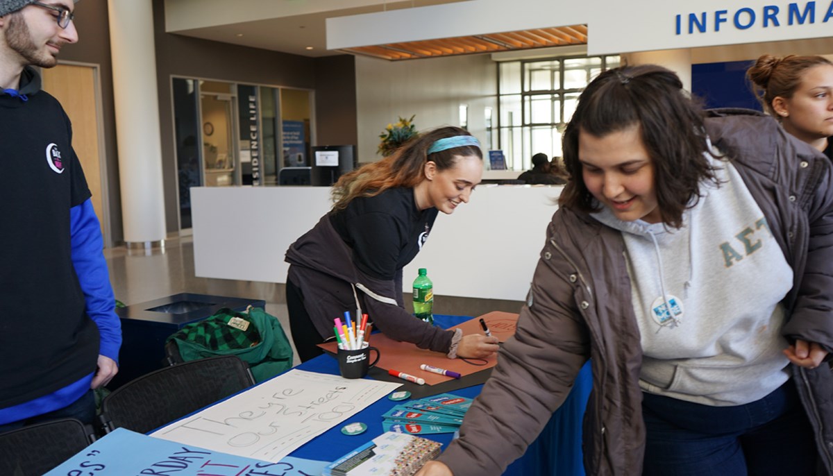 Marina Novaes works a CAPE table at a student event