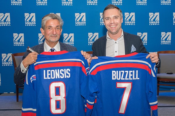 Ted Leonsis and Nick Buzzell hold up UML hockey jerseys