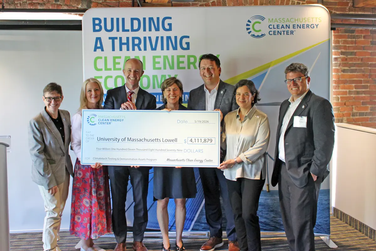 UMass Lowell officials accept a check from state officials.